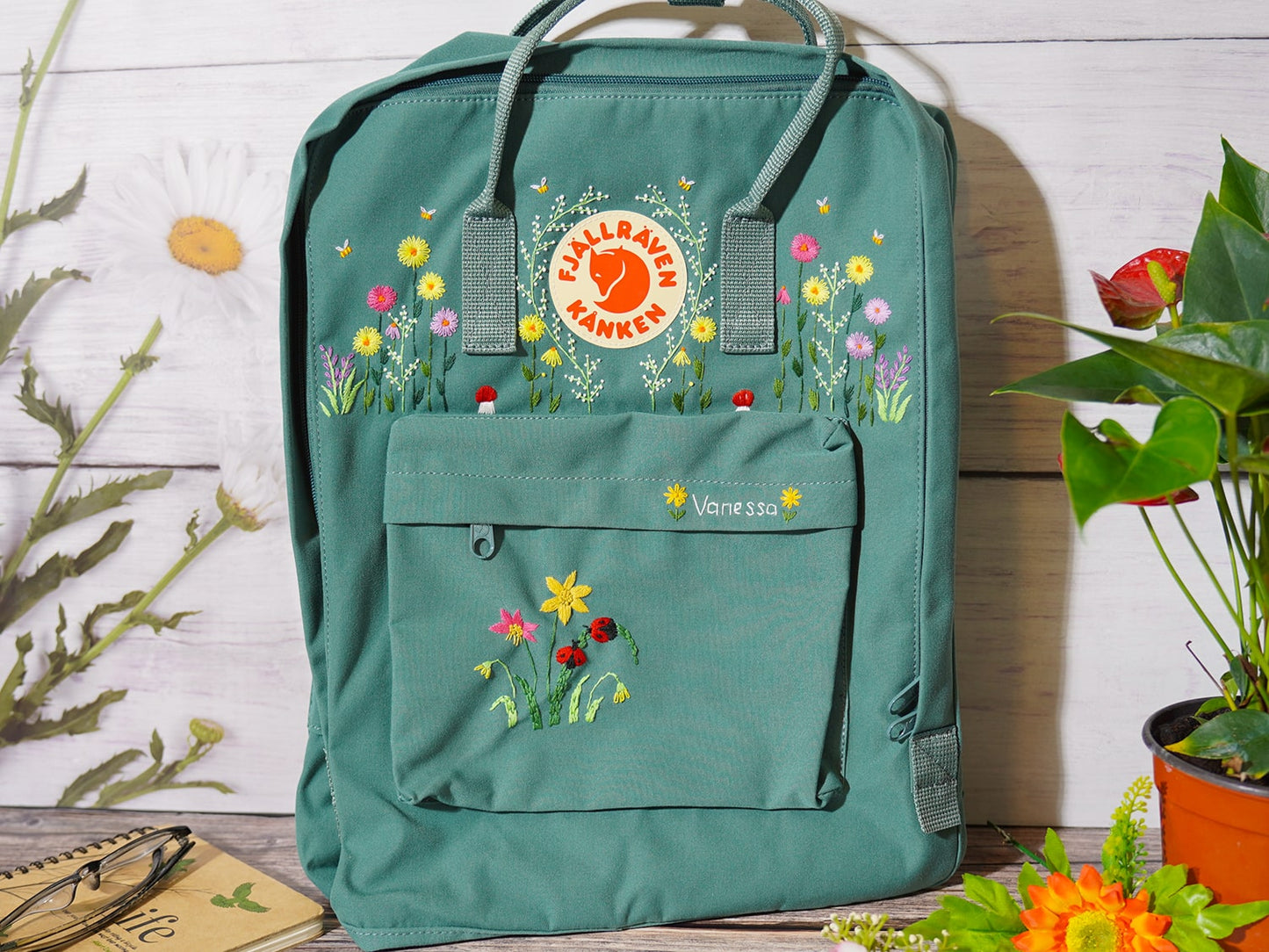 Fjallraven kanken backpack embroidered with ladybugs and colorful flowers, Ladybug embroidery design on Fjallraven Kanken backpack