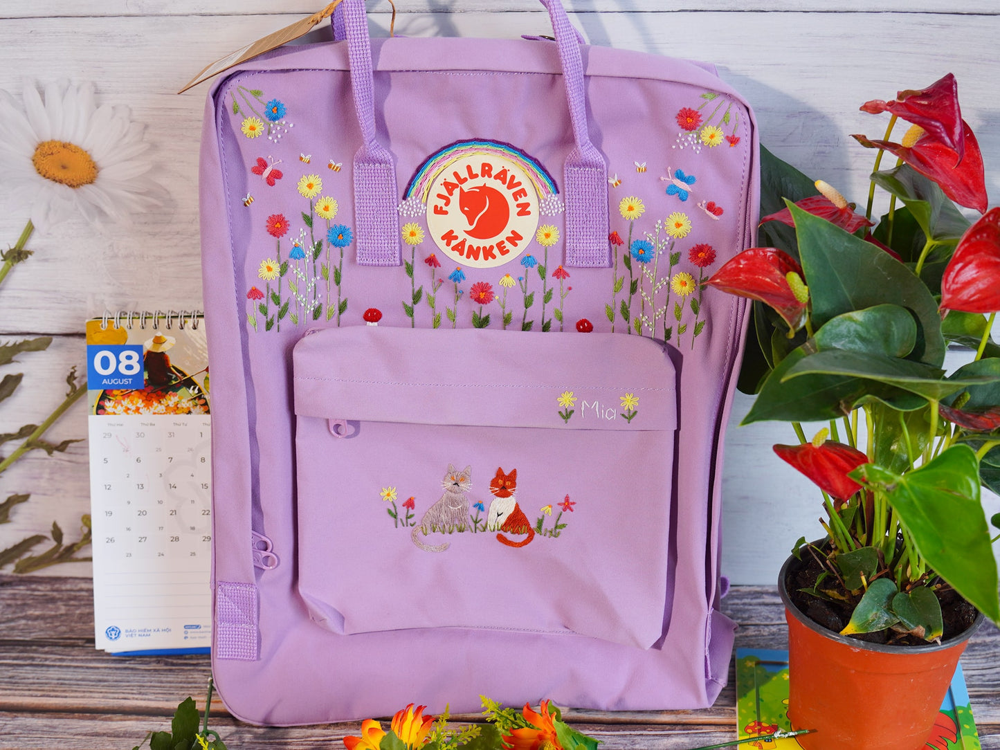 Hand embroidered fjallraven kanken backpack with rainbow flower and cat design